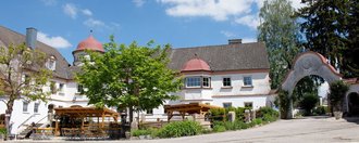 Schloss Tannegg Aussenansicht mit Innenhof unter blauem Himmel